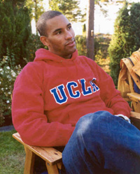 Benjamin sitting outdoors in a red UCLA hooded sweatshirt